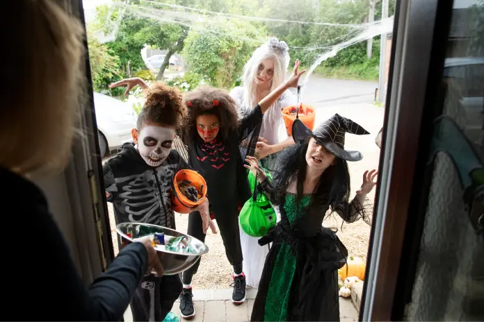 Děti v kostýmech koledující o sladkosti na Halloween Děti v kostýmech koledující o sladkosti na Halloween